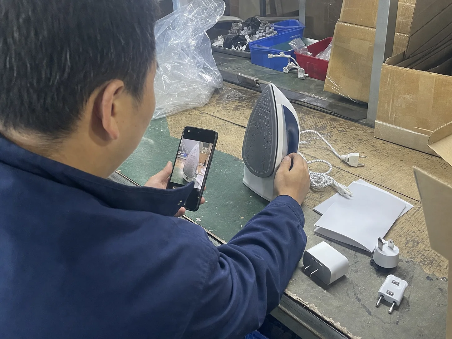 销售在车间工位核对电熨斗代工海外版本资料的现场记录