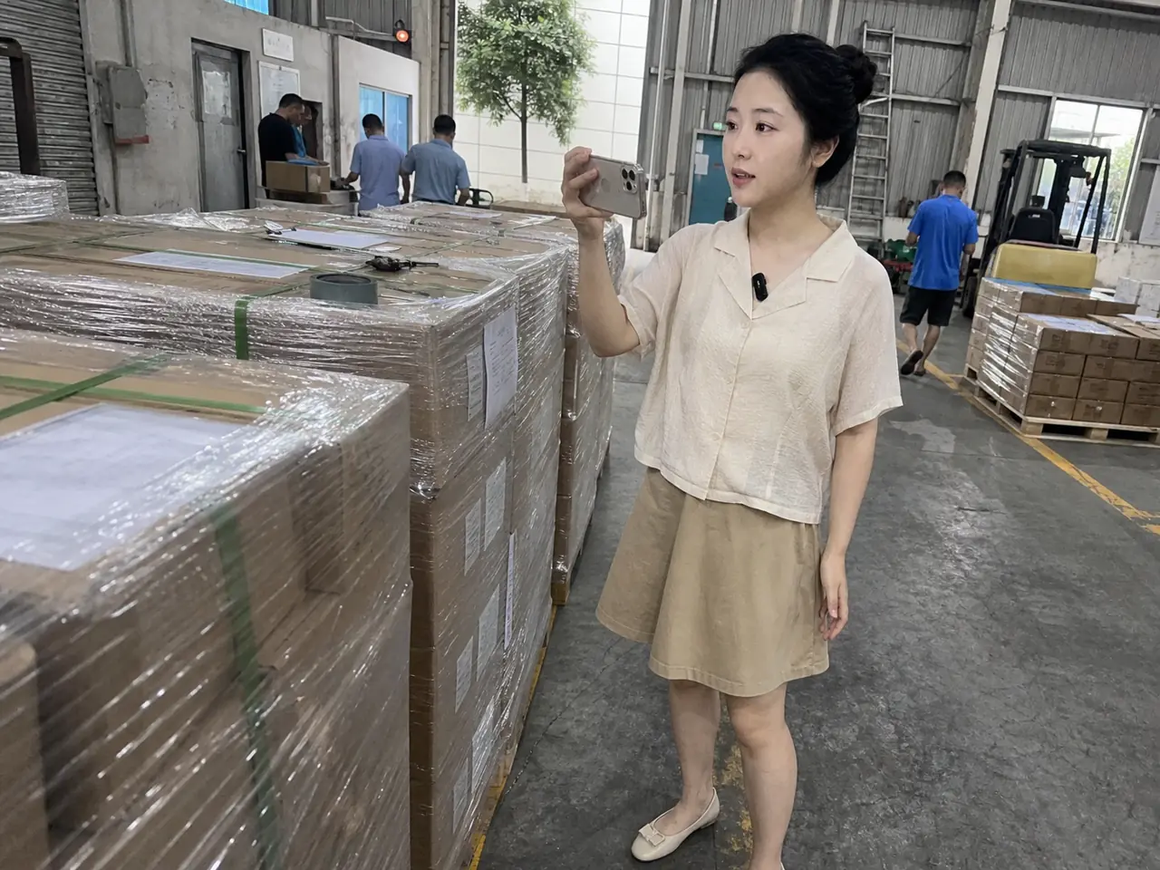 自媒体拍摄人员在仓库发运区记录防锈涂料加工包装与运输条件核对现场